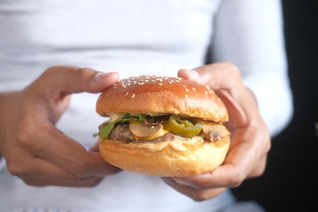 Uomo affamato in attesa di mangiare hamburger di manzo