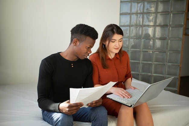 uomo africano e donna caucasica che lavorano a casa con il laptop