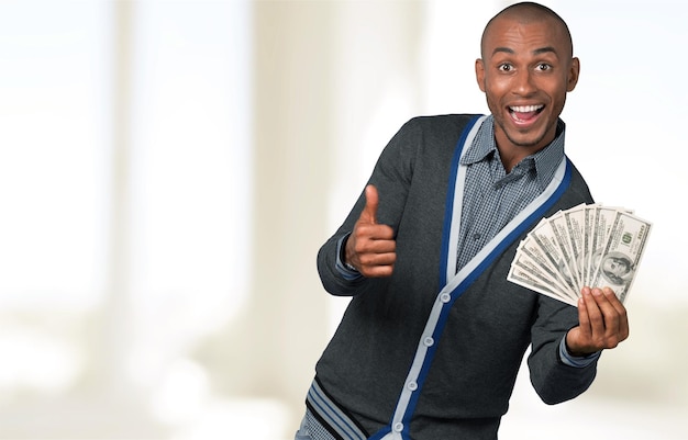 Uomo afro-americano con i dollari che mostrano il pollice in su
