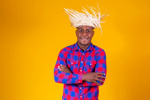 Uomo afro brasiliano che indossa abiti tipici per la Festa Junina con le braccia incrociate