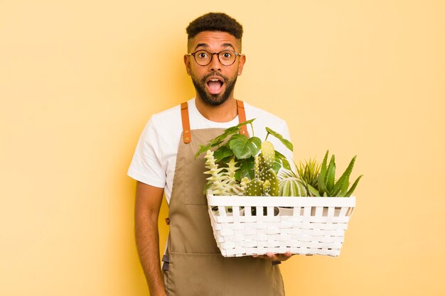 Uomo afro cool che sembra molto scioccato o sorpreso giardiniere e concetto di pianta