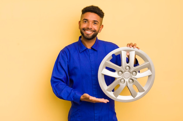 Uomo afro cool che sorride allegramente sentendosi felice e mostrando un concetto di riparatore di bici di concetto