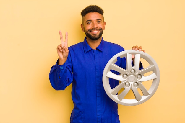 Uomo afro cool sorridente e dall'aspetto amichevole che mostra il concetto di riparatore di biciclette numero due