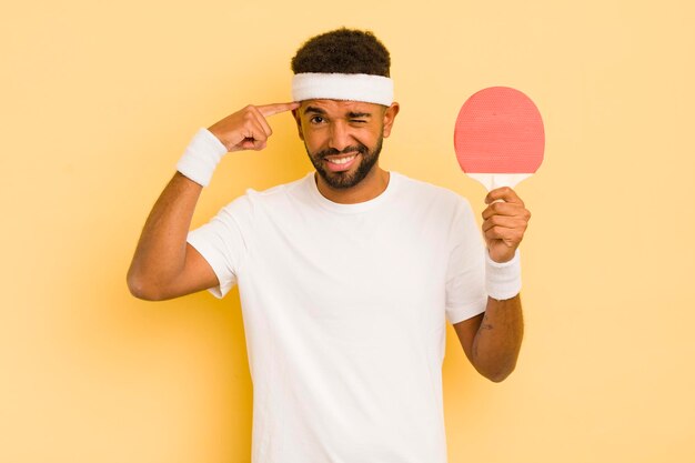 Uomo afro nero che si sente confuso e perplesso mostrando che sei un folle concetto di pingpong