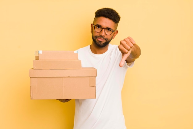 Uomo afro nero che si sente crossshowing pollice verso il concetto di scatole di spedizione