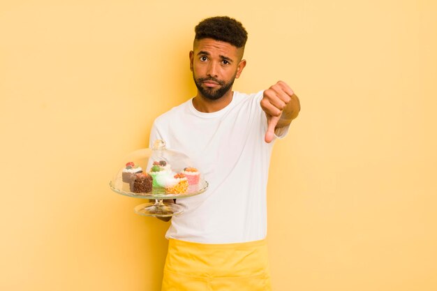 Uomo afro nero che si sente crossshowing pollice verso il concetto di torte fatte in casa