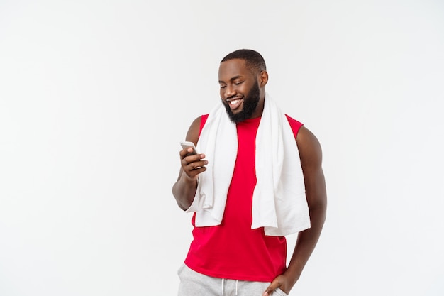 Uomo afroamericano adatto di misura che manda un sms sul cellulare