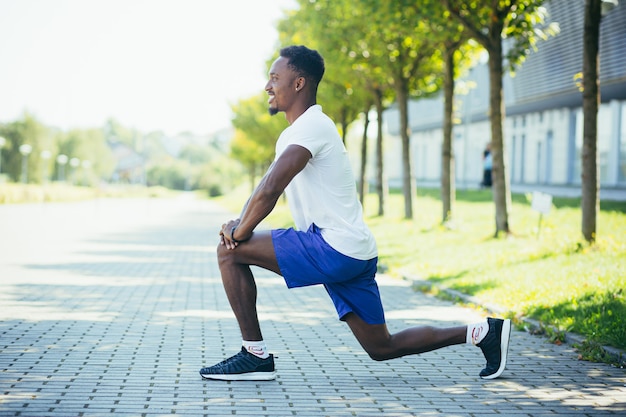 Uomo afroamericano atletico che fa allenamenti mattutini, stretching e fitness