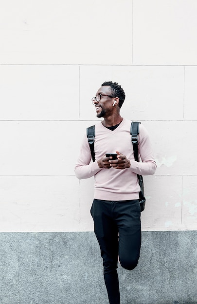 Uomo afroamericano bello che sorride con lo smartphone