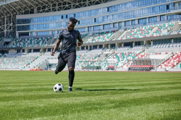 Uomo afroamericano che gioca a calcio sul campo dello stadio