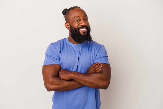 Uomo afroamericano con barba isolato su sfondo rosa che si sente sicuro, incrociando le braccia con determinazione.