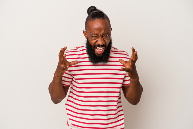 Uomo afroamericano con la barba isolato su sfondo rosa sconvolto urlando con le mani tese.