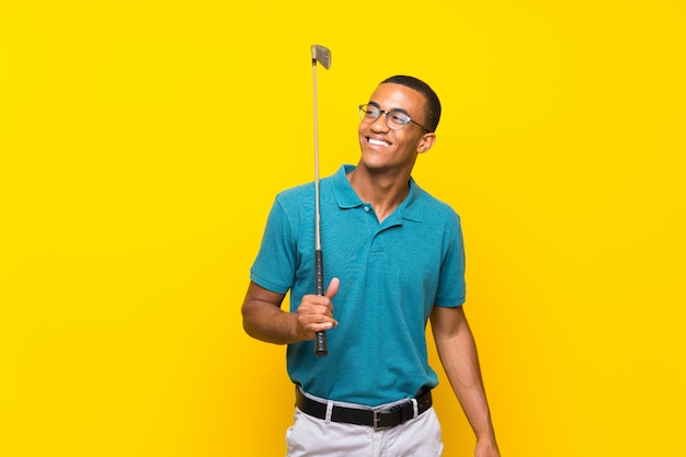 Uomo afroamericano del giocatore di giocatore di golf che cerca mentre sorridendo