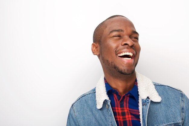 uomo afroamericano felice che ride con la giacca di jeans su sfondo bianco