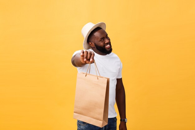 Uomo afroamericano felice che tiene i sacchetti della spesa