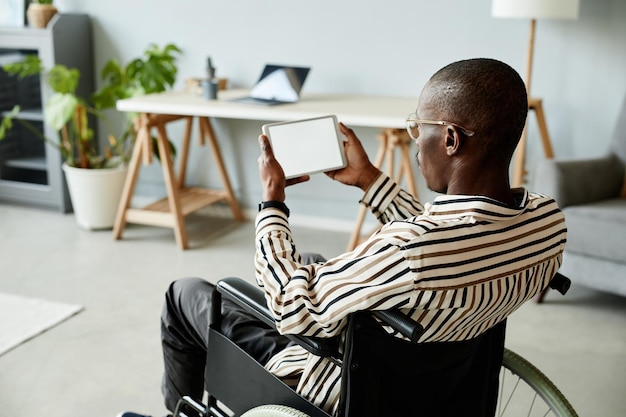 Uomo afroamericano in sedia a rotelle con tablet