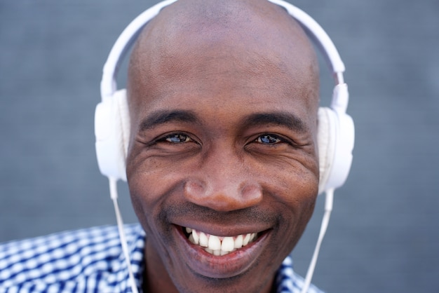 Uomo afroamericano sorridente che ascolta la musica con le cuffie