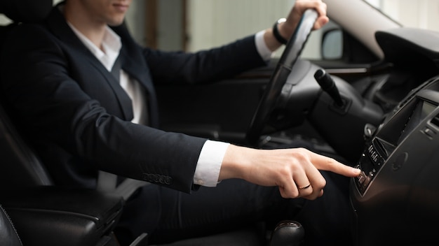 Uomo alla guida della sua auto elegante per i servizi di taxi