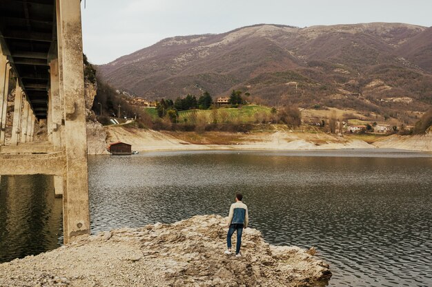 Uomo alla moda che guarda uno scenario meraviglioso in montagna durante la primavera in Italia.