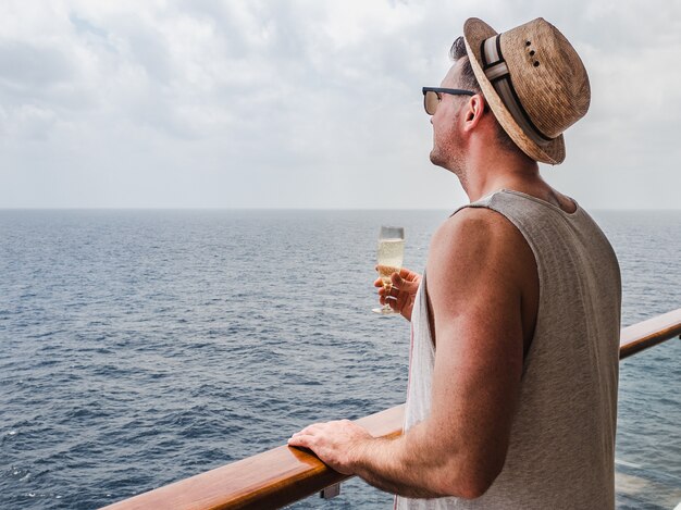 Uomo alla moda che tiene un bicchiere di champagne