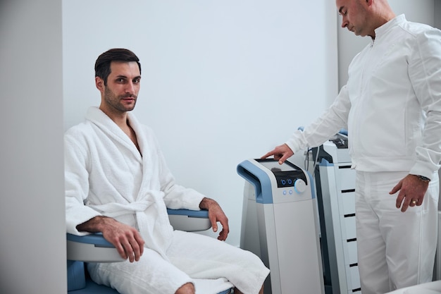 Uomo alla moda sorridente durante il controllo nel centro medico