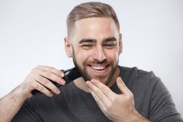 Uomo allegro che taglia la sua barba