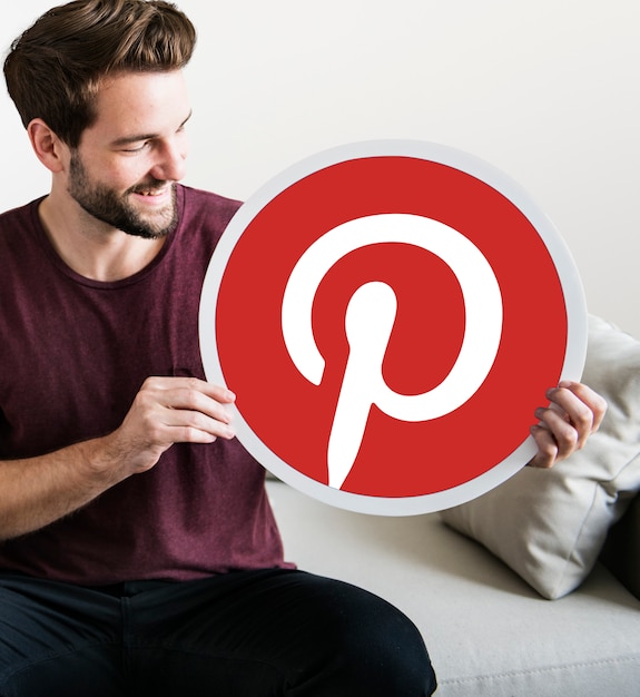 Uomo allegro che tiene un&#39;icona di Pinterest