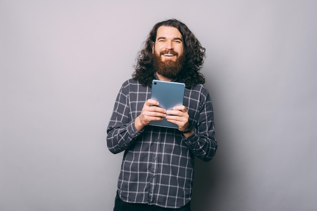 Uomo allegro con tablet in studio