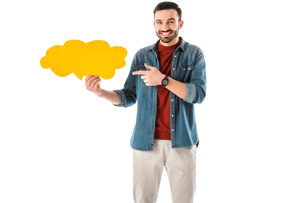 Uomo allegro in camicia di jeans che punta con il dito alla bolla di pensiero isolata su bianco