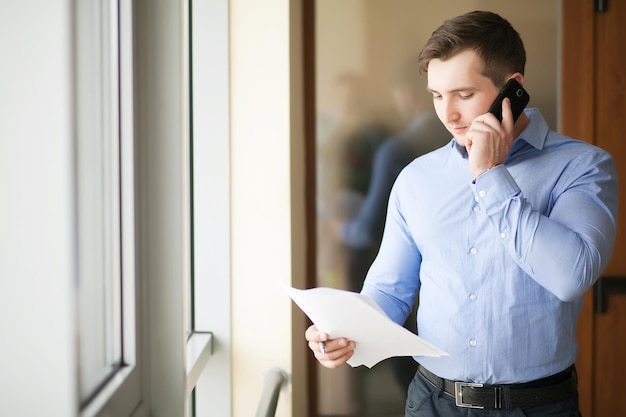 Uomo allegro in ufficio che risponde al telefono