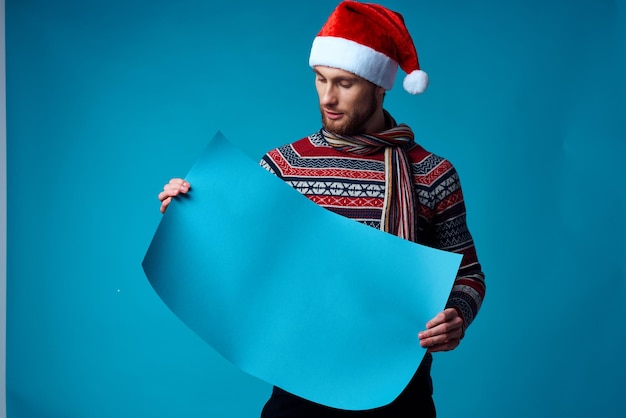 Uomo allegro in un poster di mockup blu di natale sfondo blu