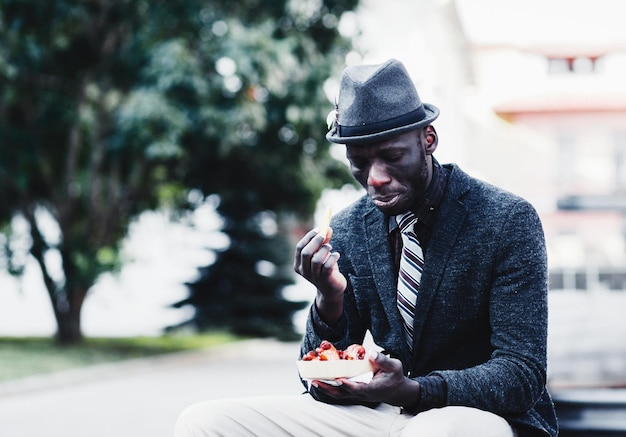 Uomo americano che mangia fast food