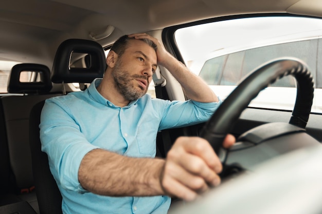 Uomo annoiato sconvolto alla guida di una nuova auto in città