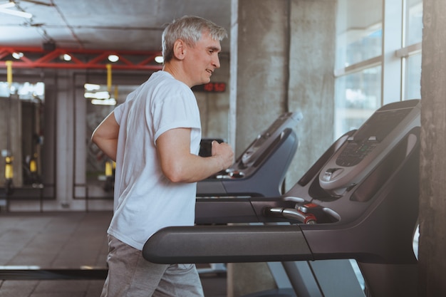 Uomo anziano allenandovi in palestra