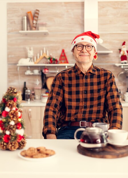 Uomo anziano anziano allegro che sorride celebrando il natale