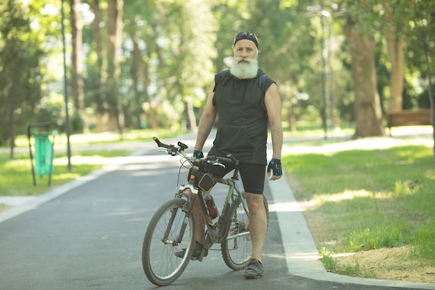 Uomo anziano barbuto con una bicicletta