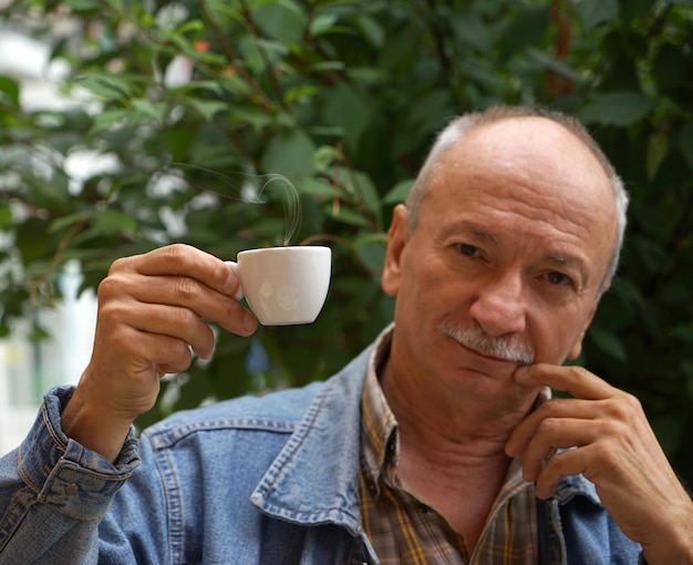 Uomo anziano che beve tazza di caffè