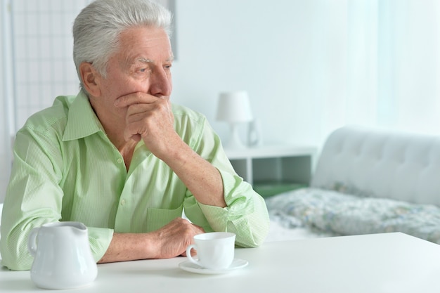 Uomo anziano che beve una tazza di caffè a casa