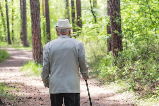 uomo anziano che cammina nella foresta