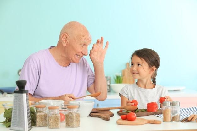 Uomo anziano che cucina insieme a sua nipote in cucina