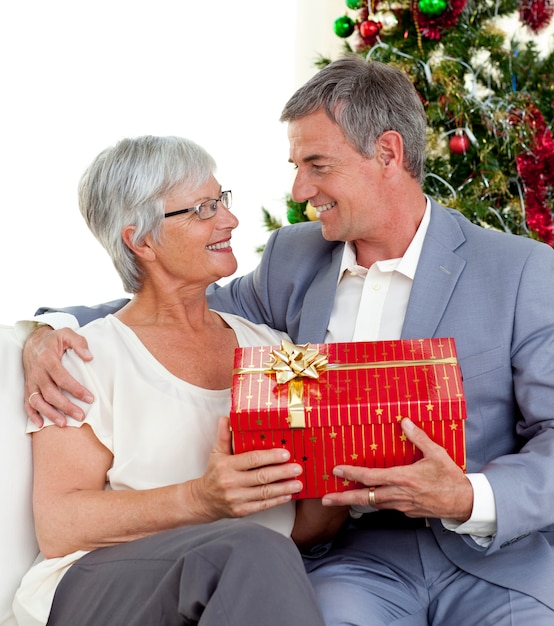 Uomo anziano che dà un regalo di Natale a sua moglie