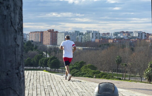 Uomo anziano che fa jogging all'aperto con vista sullo skyline