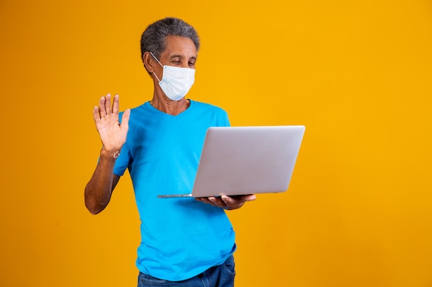 Uomo anziano che fa una videochiamata al computer con i familiari durante la pandemia. Concetto di quarantena