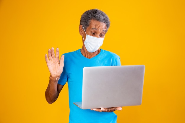 Uomo anziano che fa una videochiamata al computer con i familiari durante la pandemia. Concetto di quarantena