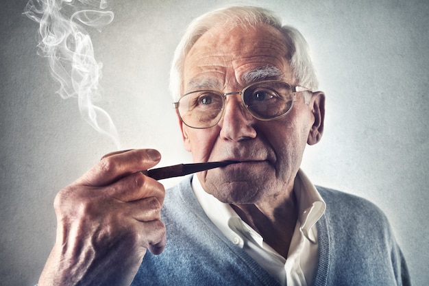 Uomo anziano che fuma la pipa