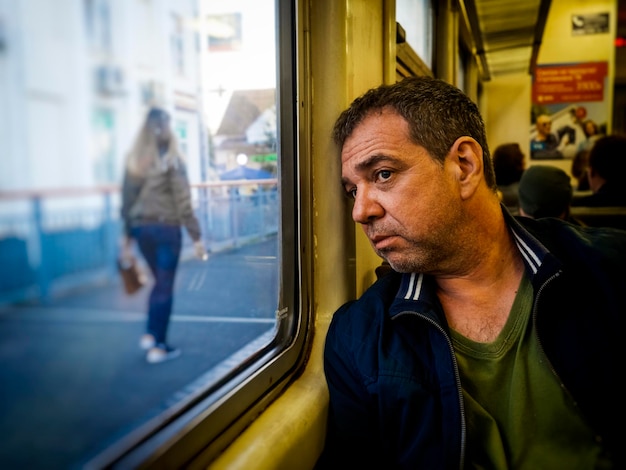 Uomo anziano che guarda attraverso la finestra del treno