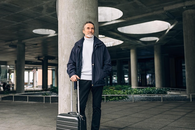 Uomo anziano che guarda lontano mentre è in piedi all'aperto