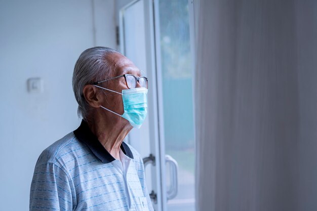 Uomo anziano che indossa una maschera medica a casa