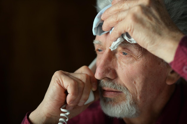 Uomo anziano che parla al telefono