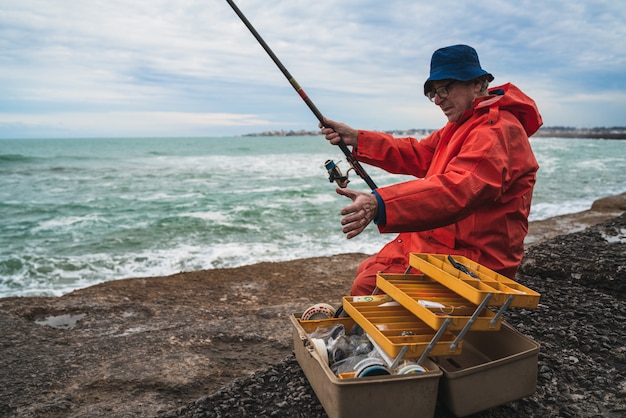 Uomo anziano che pesca nel mare.